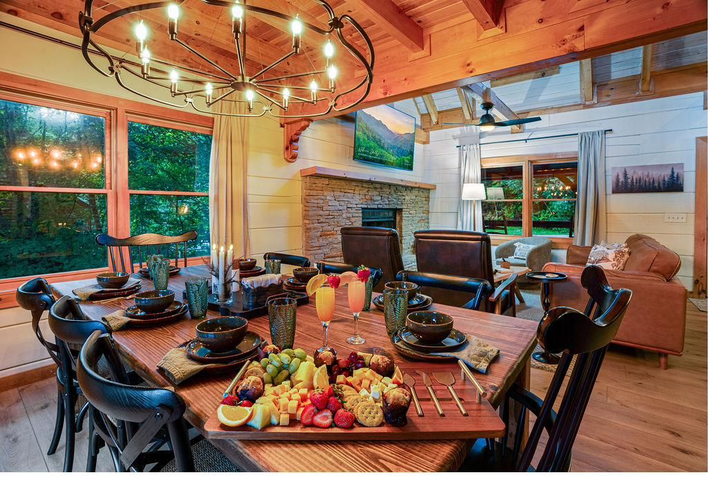 Dining table at The Smoky Edit set for a group with a charcuterie spread under an iron chandelier